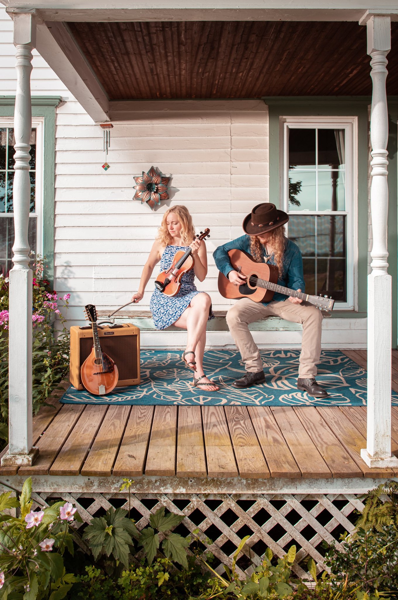Kody and Herren playing instruments on front porch.