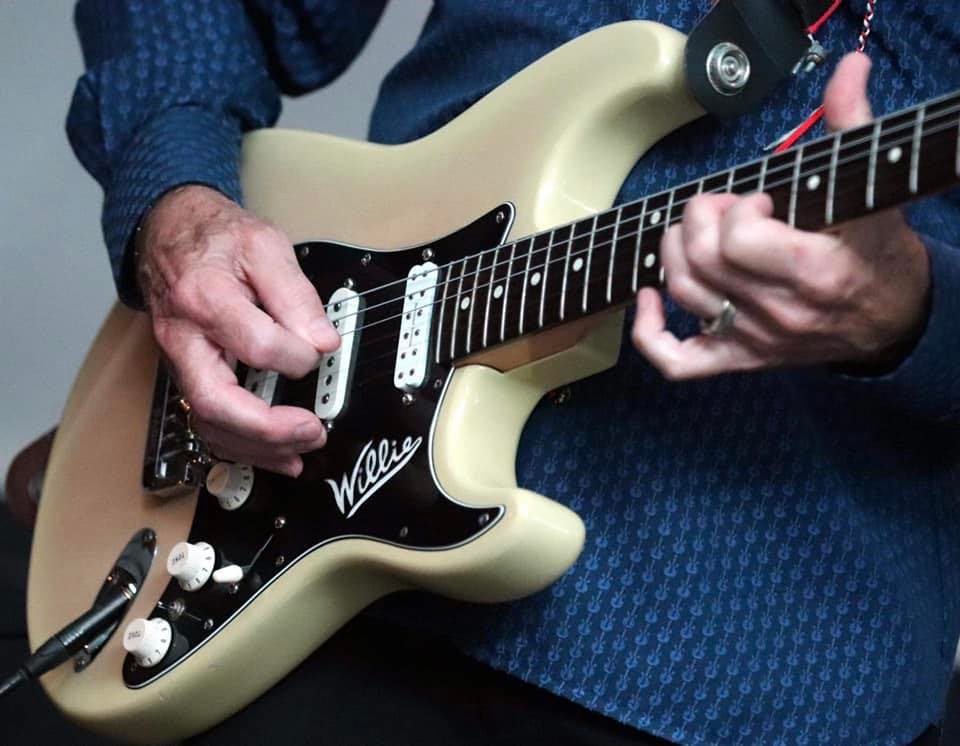 StratCatWillieandtheStrays Close up of Willie playing guitar.