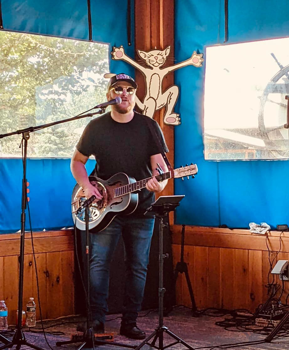 TrevorClark2 Trevor Clark playing guitar and singing at The Oasis bar.