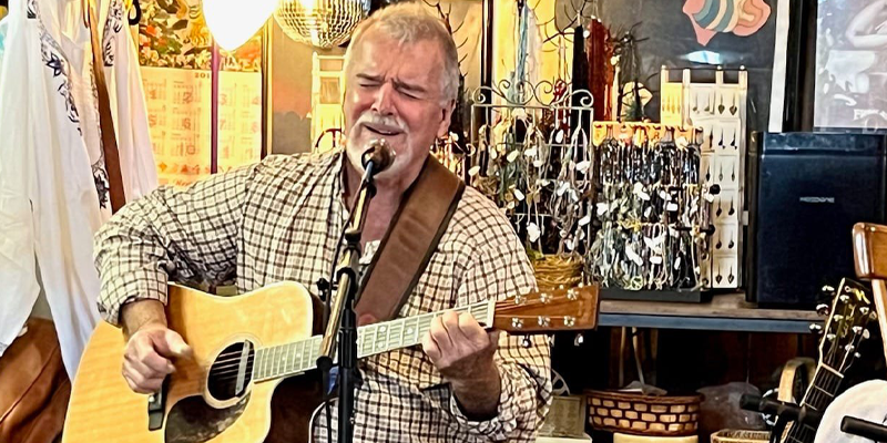 Delta Mike playing guitar and singing at a show.