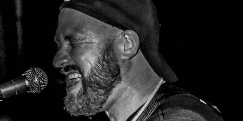 PatComstockScottMuir Black and white photo of Pat Comstock singing his heart out.